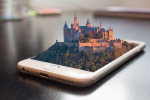 Iphone con un castello in tre dimensioni che esce dallo schermo - L'importanza del sito web, a chi rivolgersi